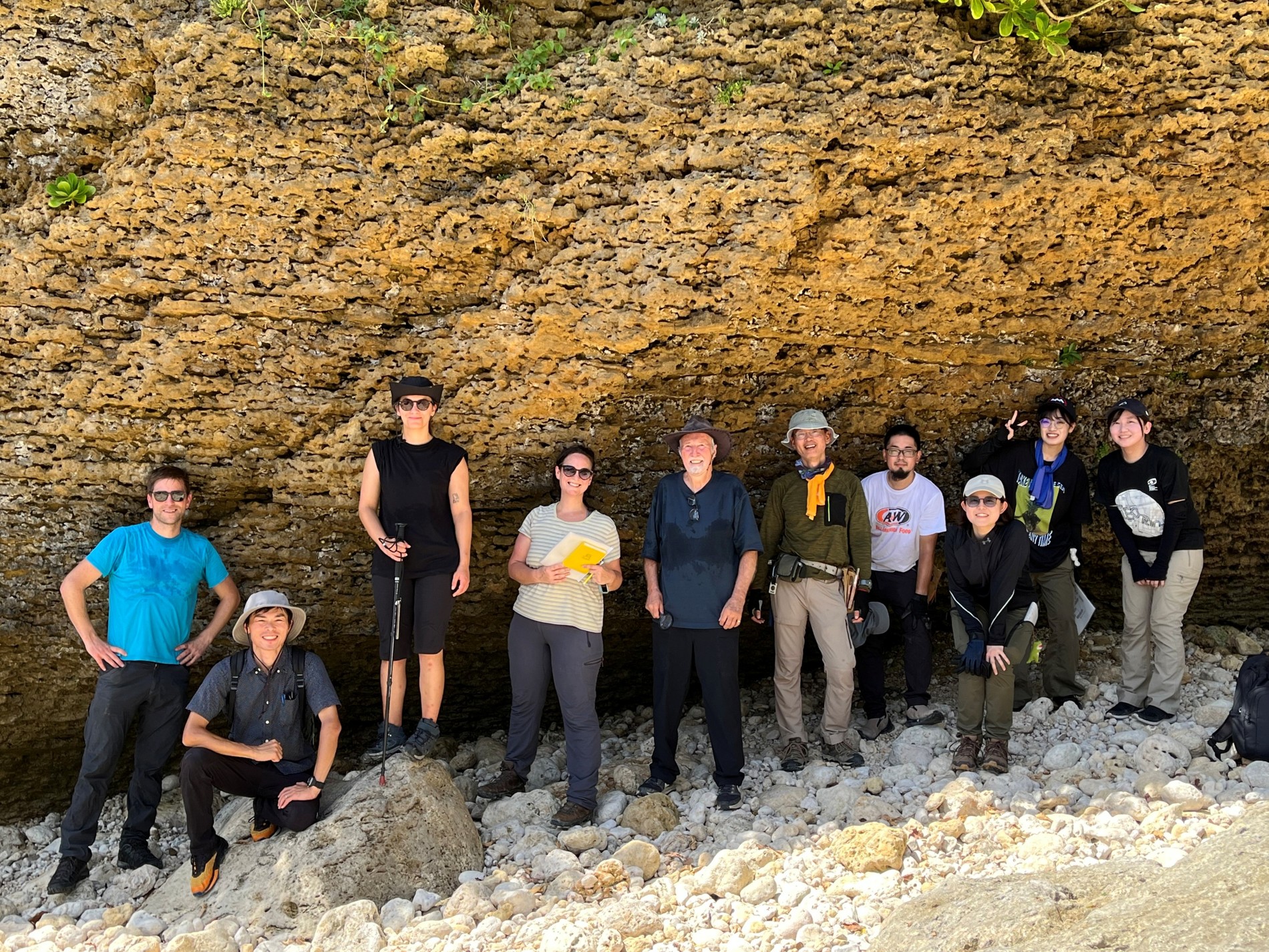 Field team with Professor Dorrik Stow at a layered carbonate outcrop during fieldwork